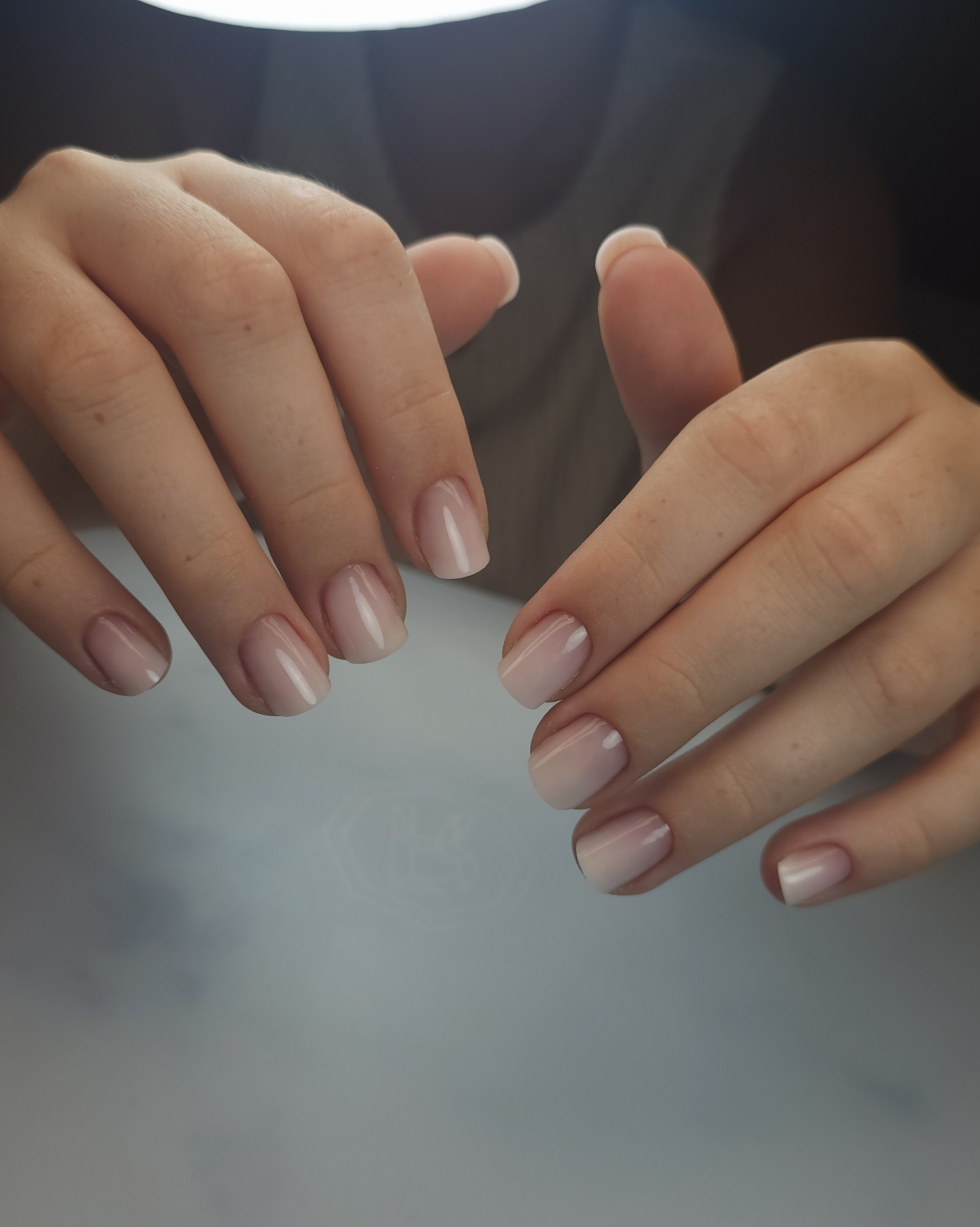 Beide Hände mit kurzer, natürlicher Modellage in zartem Milchrosa
